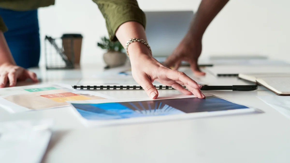 People looking at visual materials on board room table